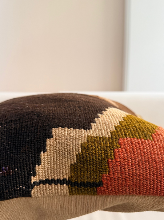 Unique hand-knotted kilim cushion featuring a large abstract geometric pattern in charcoal, moss green, and fuchsia