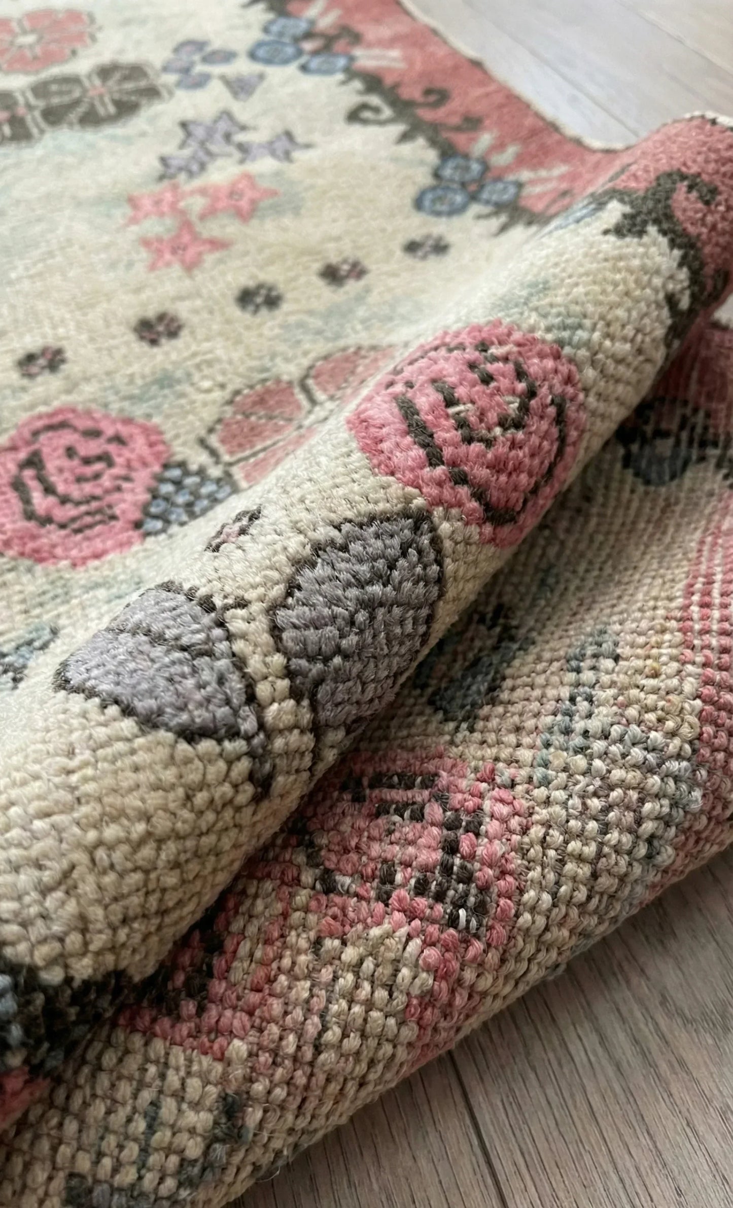 Close-up of a semi-antique Anatolian rug with pink and gray designs