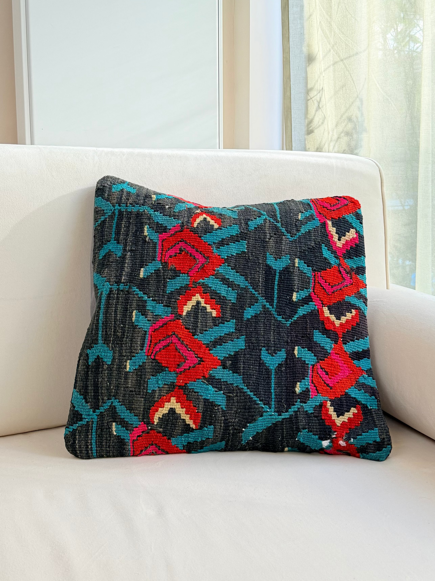 Vintage floral kilim cushion cover with vibrant red rose motifs on a deep charcoal hand-spun wool background