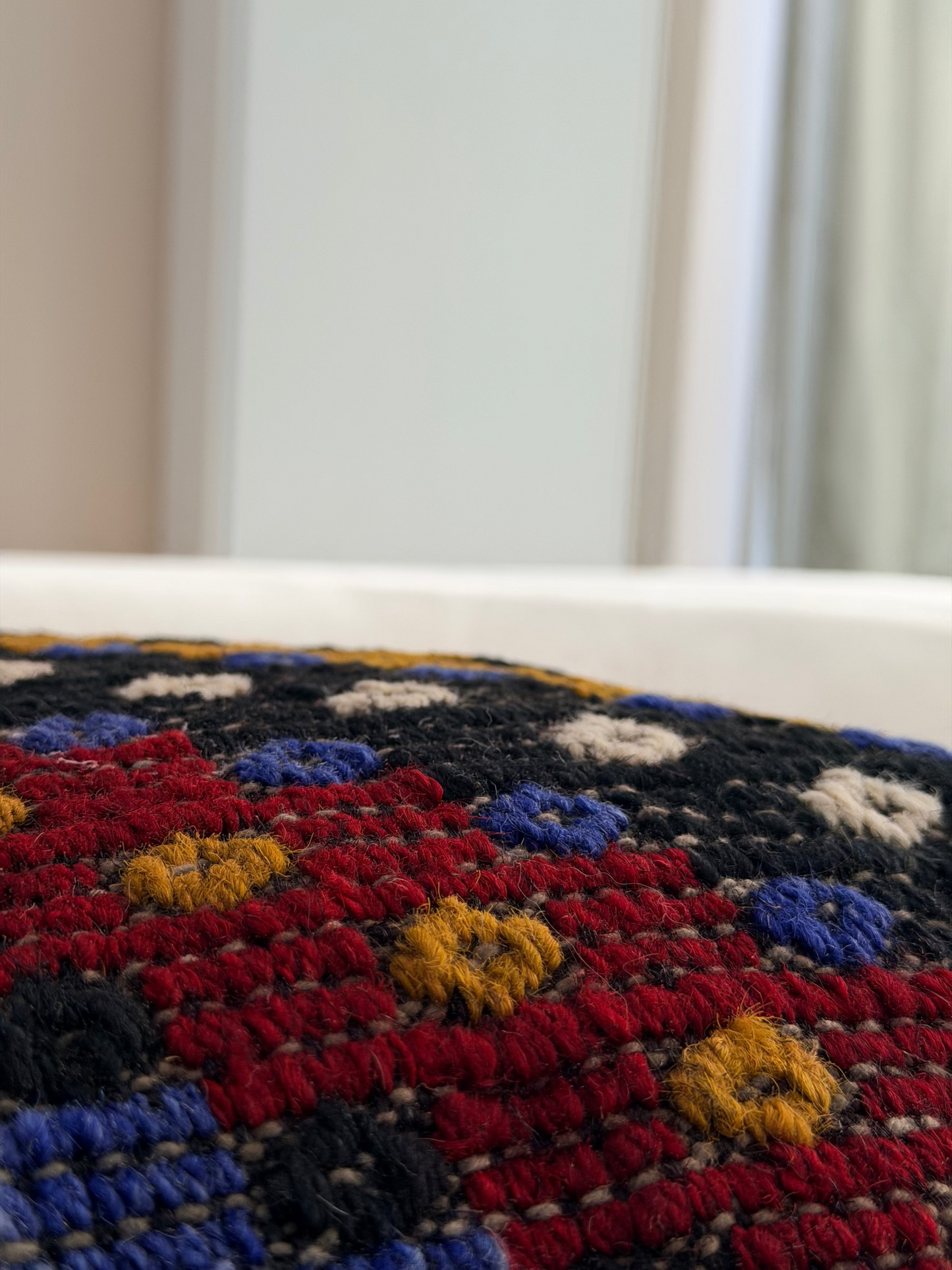 Textured Anatolian "pıtırak" popcorn weave cushion cover with colorful geometric motifs on a charcoal wool base