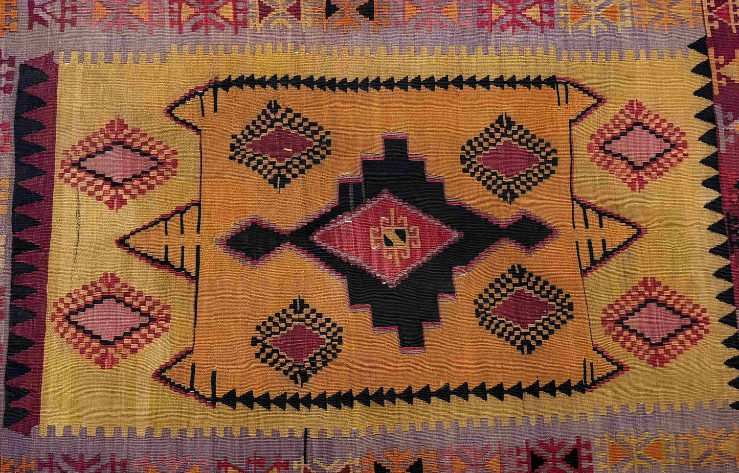 Decorative Anatolian rug with geometric pattern on a tiled floor