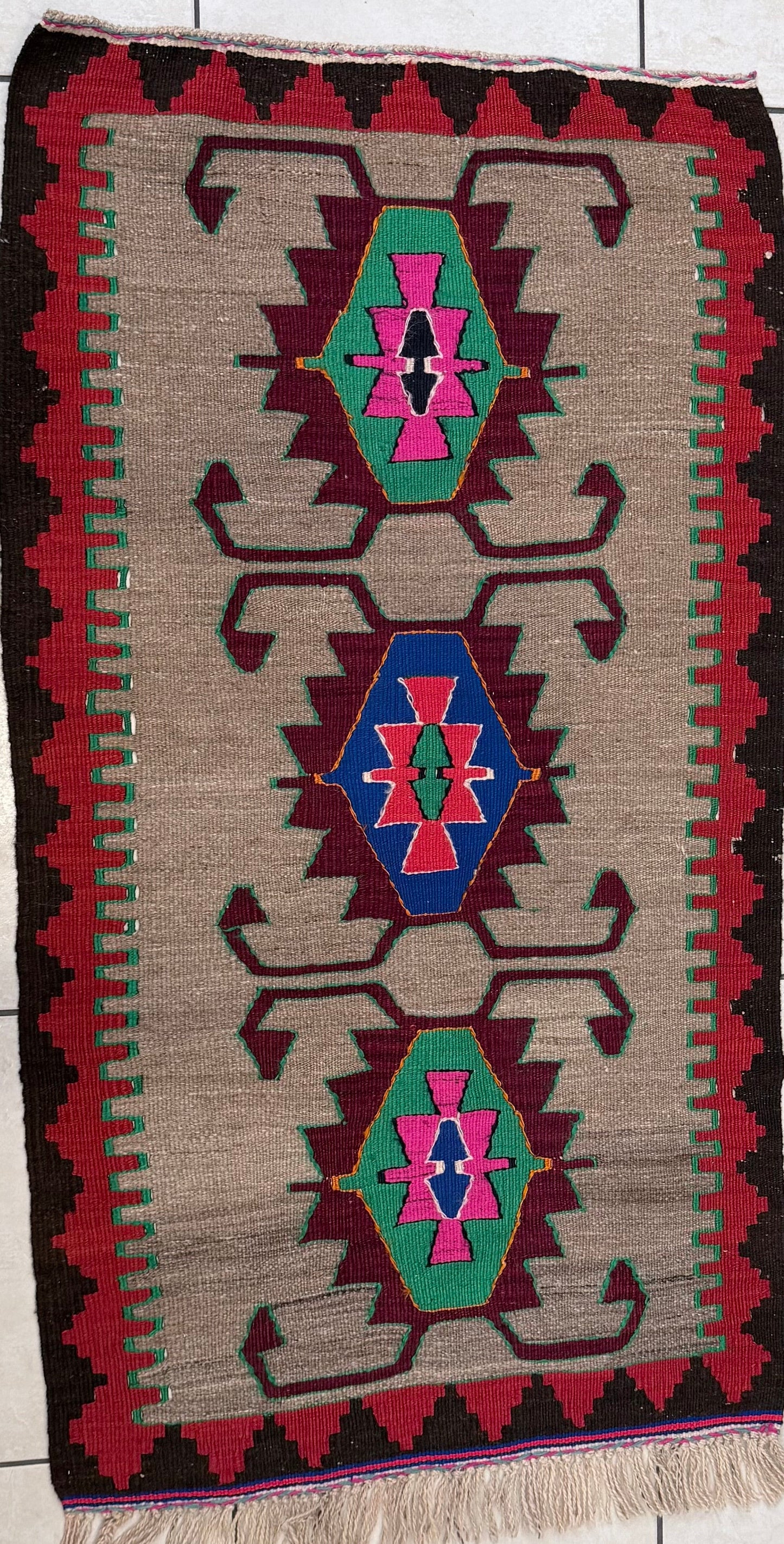 Woven turkish rug with geometric pattern on a tiled floor