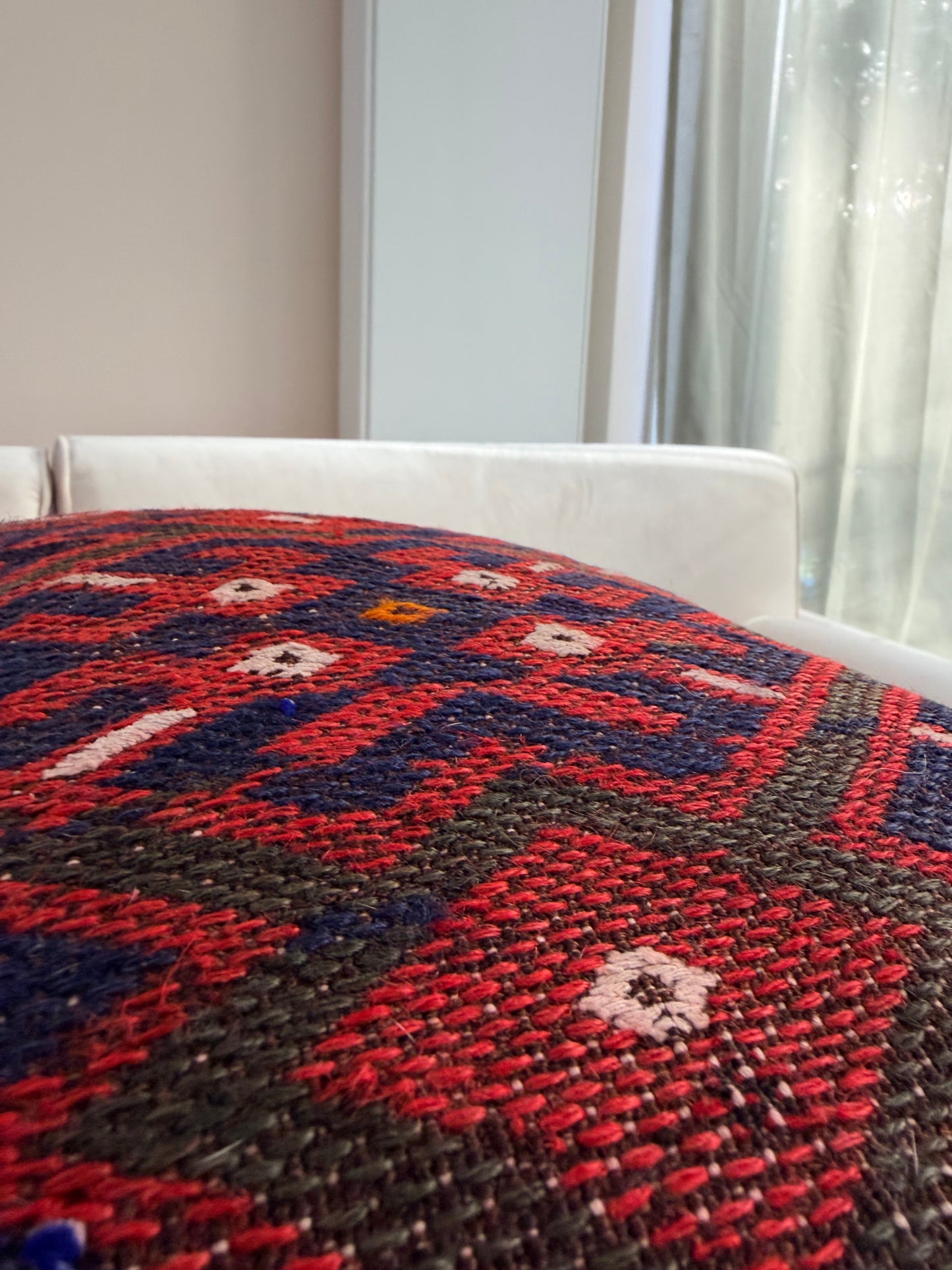 Classic geometric kilim pillow cover featuring red and navy diamond motifs, repurposed from a vintage Turkish rug.