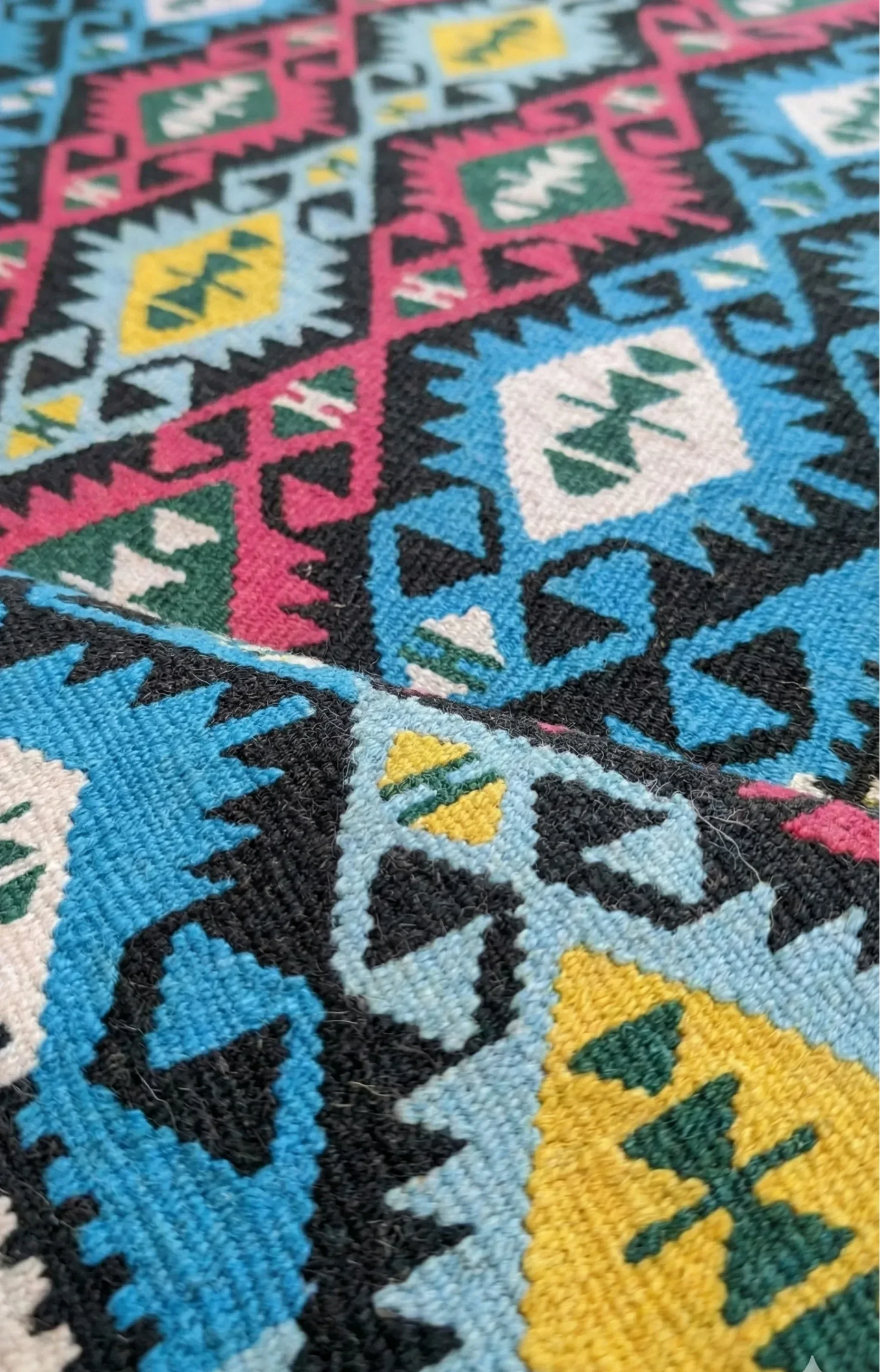 A vibrant, vintage Turkish Kilim runner featuring a colorful geometric pattern in turquoise, pink, and yellow