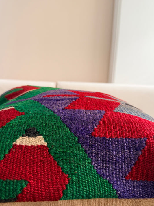Authentic wool cushion cover with intricate geometric patterns in emerald green, crimson red, and muted violet