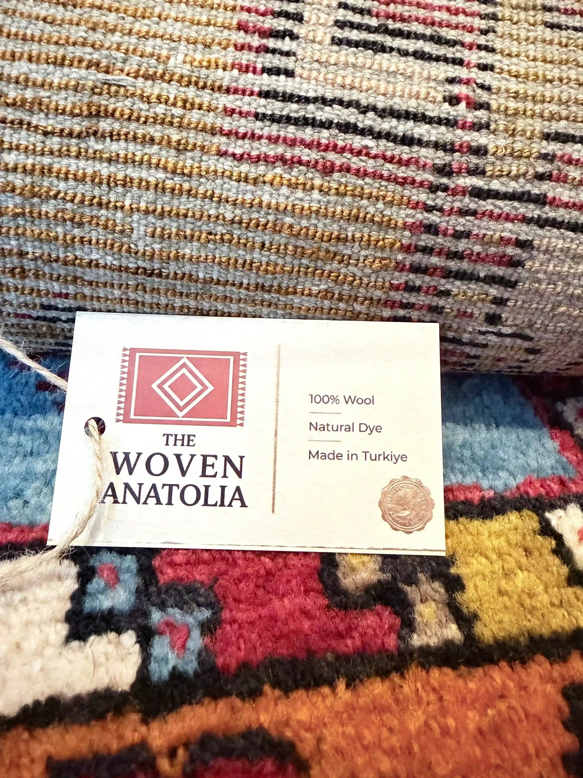 Colorful woven Anatolian rug with a 'The Woven Anatolia' tag.