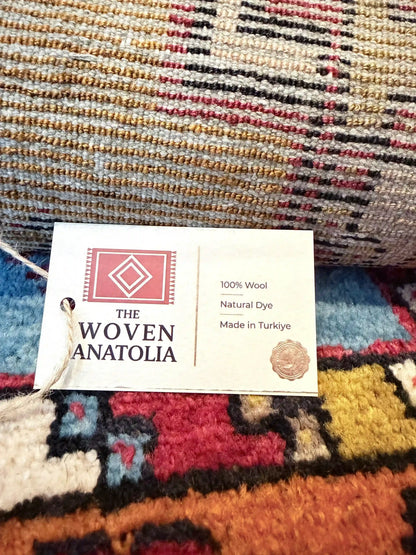 Colorful woven Anatolian rug with a 'The Woven Anatolia' tag.