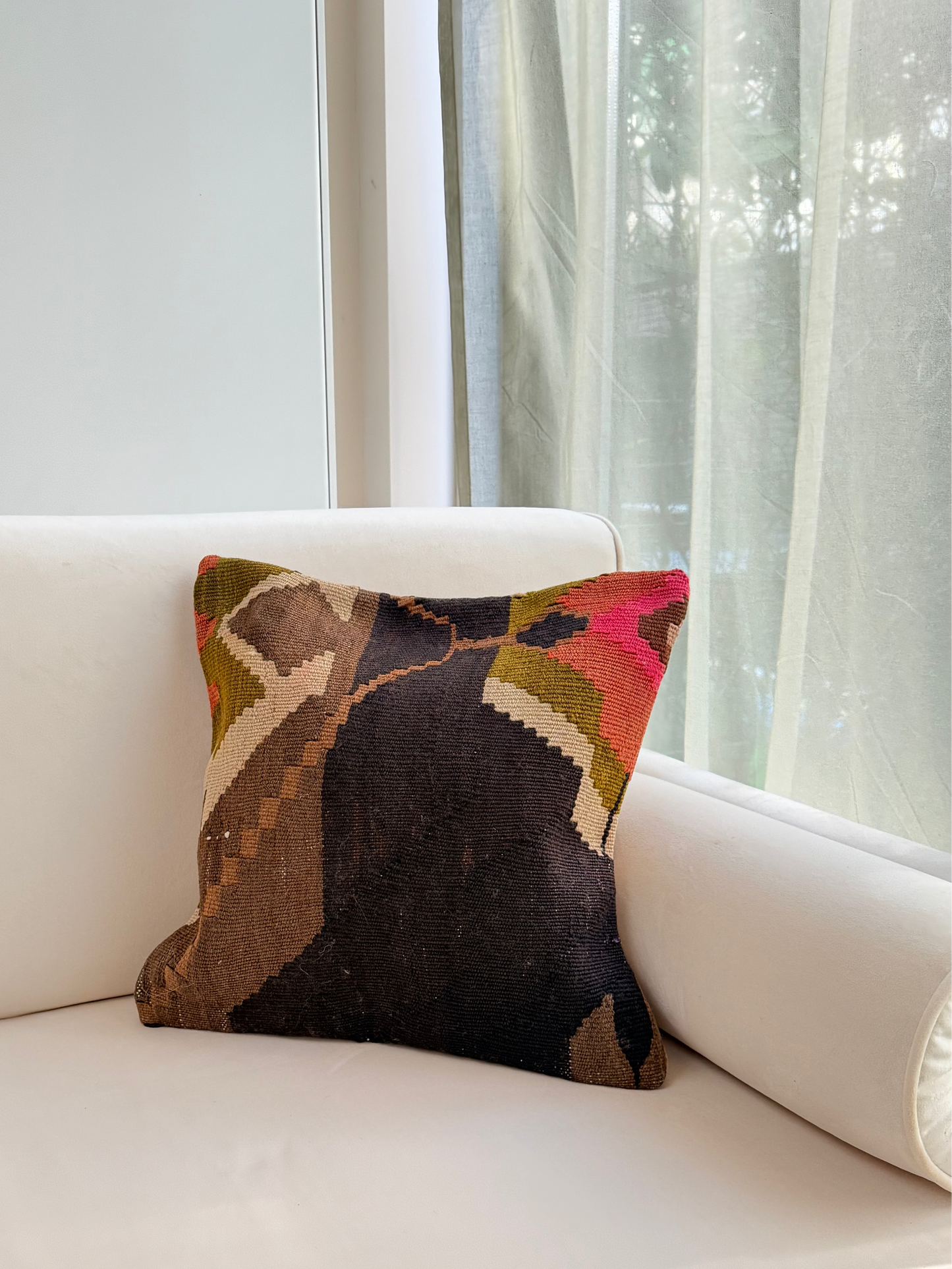 Unique hand-knotted kilim cushion featuring a large abstract geometric pattern in charcoal, moss green, and fuchsia.