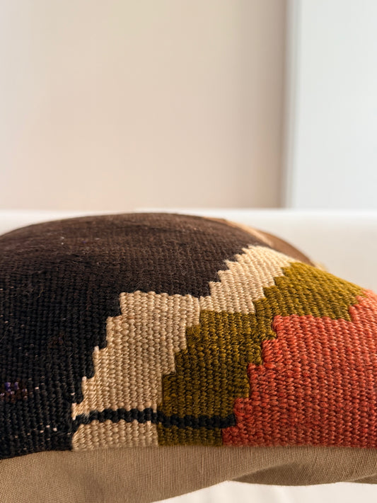 Unique hand-knotted kilim cushion featuring a large abstract geometric pattern in charcoal, moss green, and fuchsia