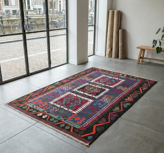 Colorful Anatolian rug on a gray floor with large windows showing an outdoor scene.