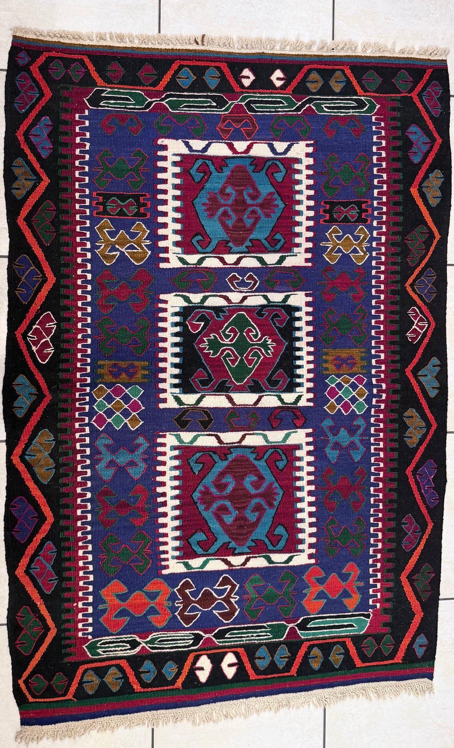 Anatolian rug with geometric pattern on a tiled floor