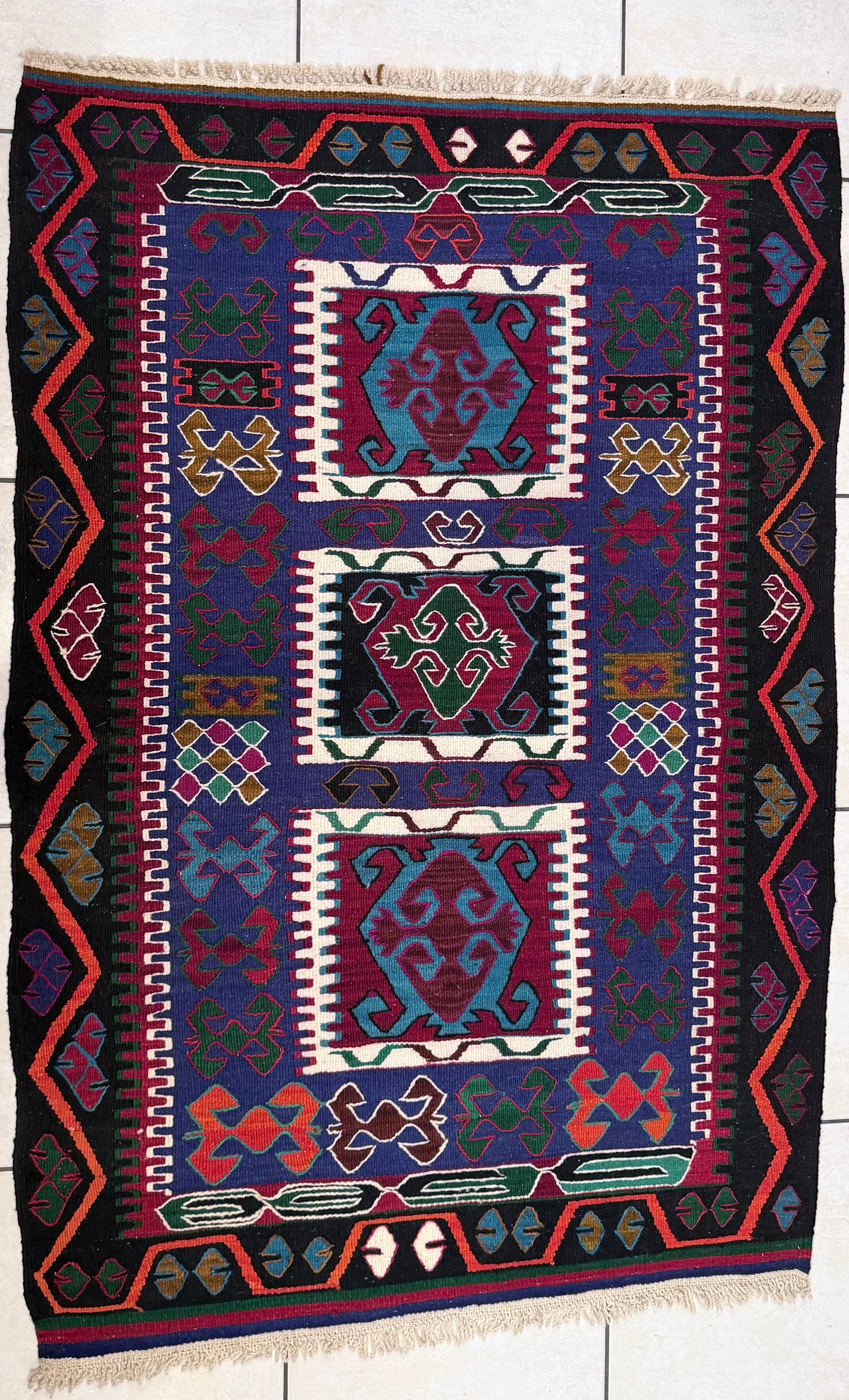 Anatolian rug with geometric pattern on a tiled floor