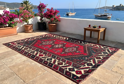 Vintage Turkish rug with triple medallion, styled on a stone terrace in Bodrum