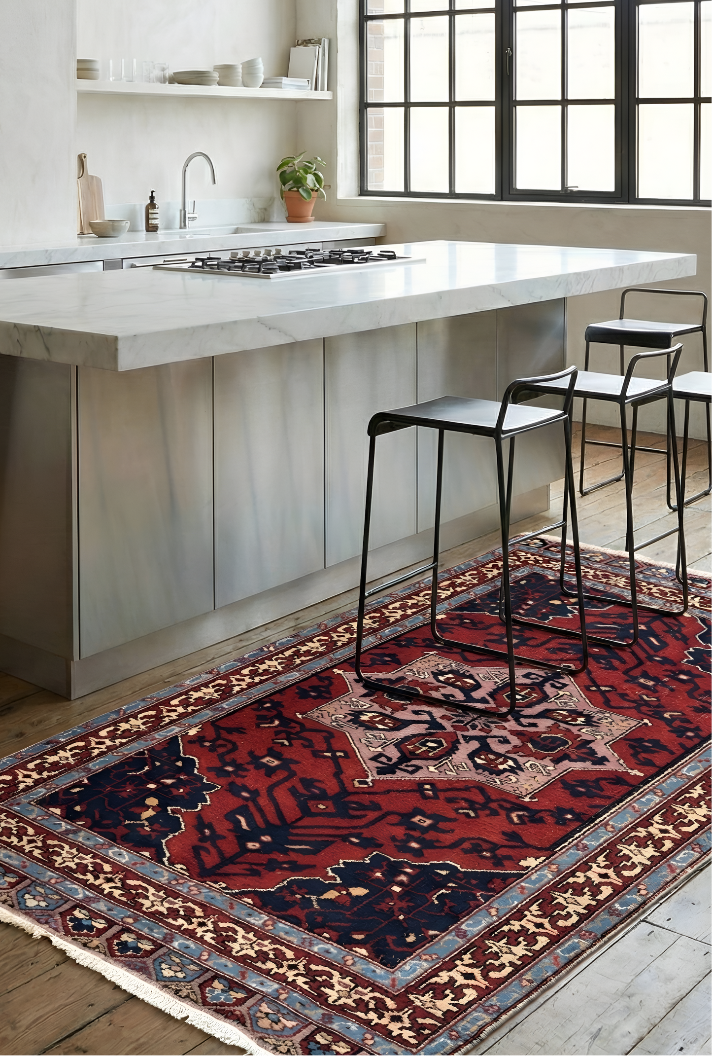 Modern kitchen with a large window, white island, and Anatolian wool rug on the floor