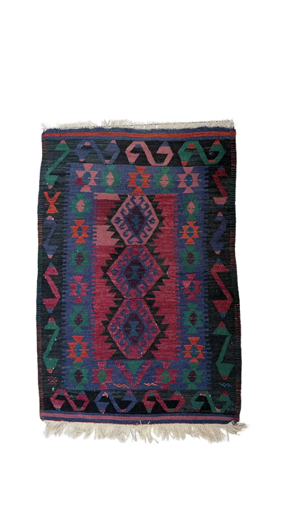 Colorful patterned turkish rug with geometric design on a white 