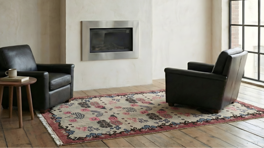 Living room with two black armchairs, a small table, and  anatolian wool, natural dye, floral rug