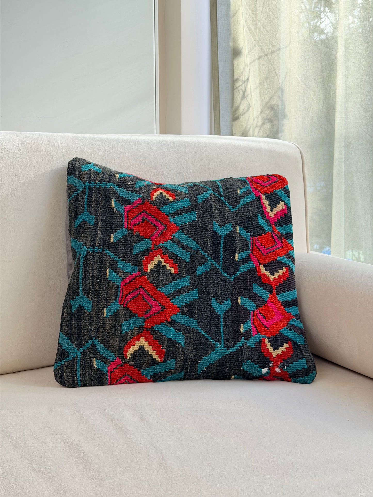 Vintage floral kilim cushion cover with vibrant red rose motifs on a deep charcoal hand-spun wool background