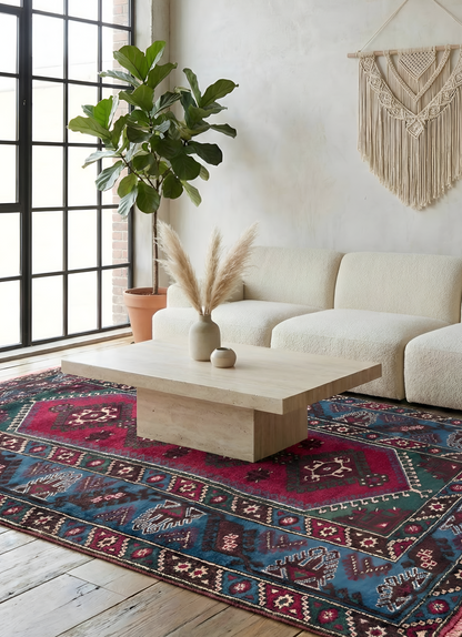 Living room with a colorful patterned hand-knotted  anatolian rug, white sofa, and marble table.