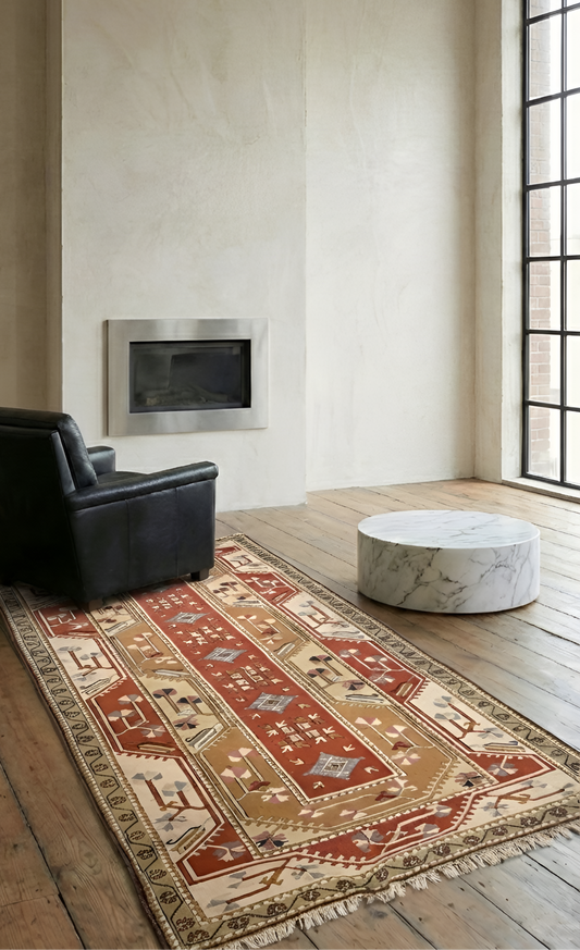 Living room with a patterned anatolian hand-knotted rug, black armchair, and marble table.