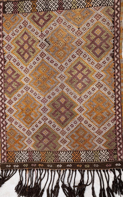 Traditional patterned Anatolian kilim rug  with geometric design and fringes at the bottom