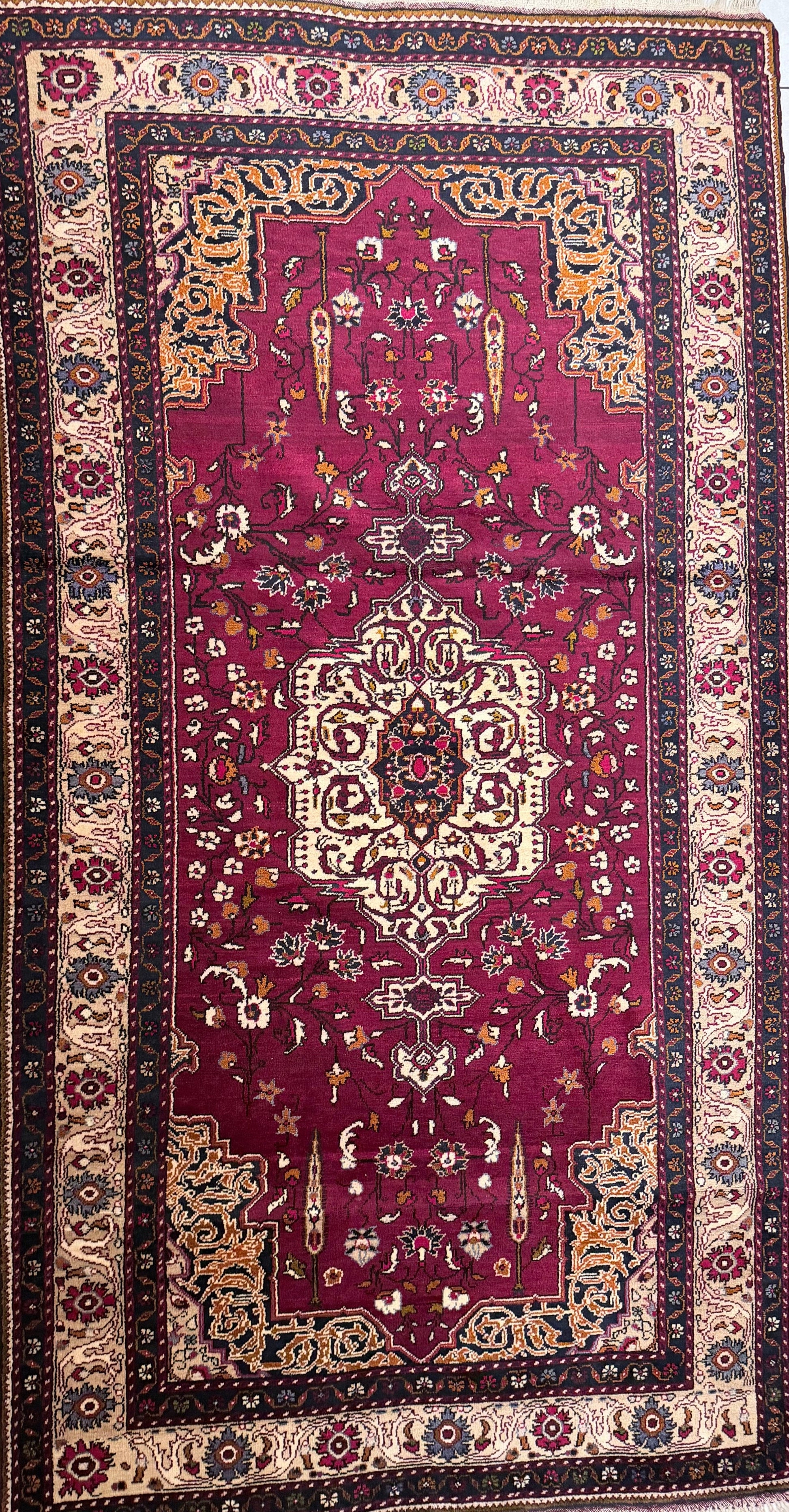 Semi antique Anatolian burgundy rug with intricate patterns on a tiled floor