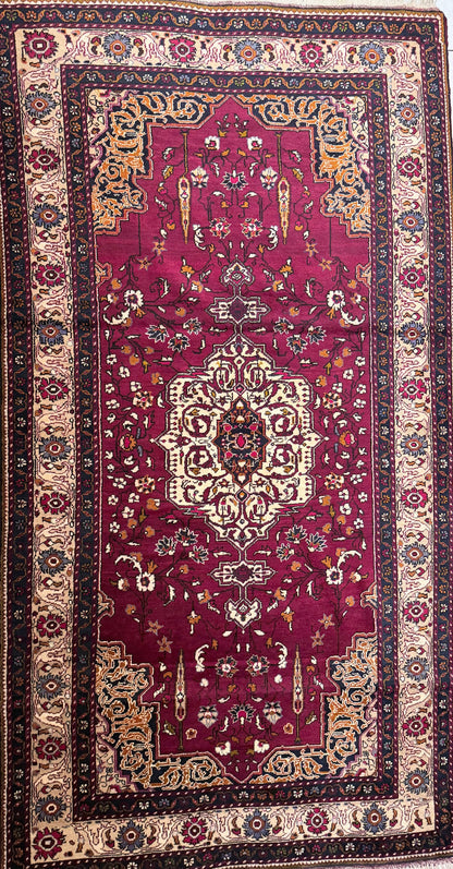 Semi antique Anatolian burgundy rug with intricate patterns on a tiled floor