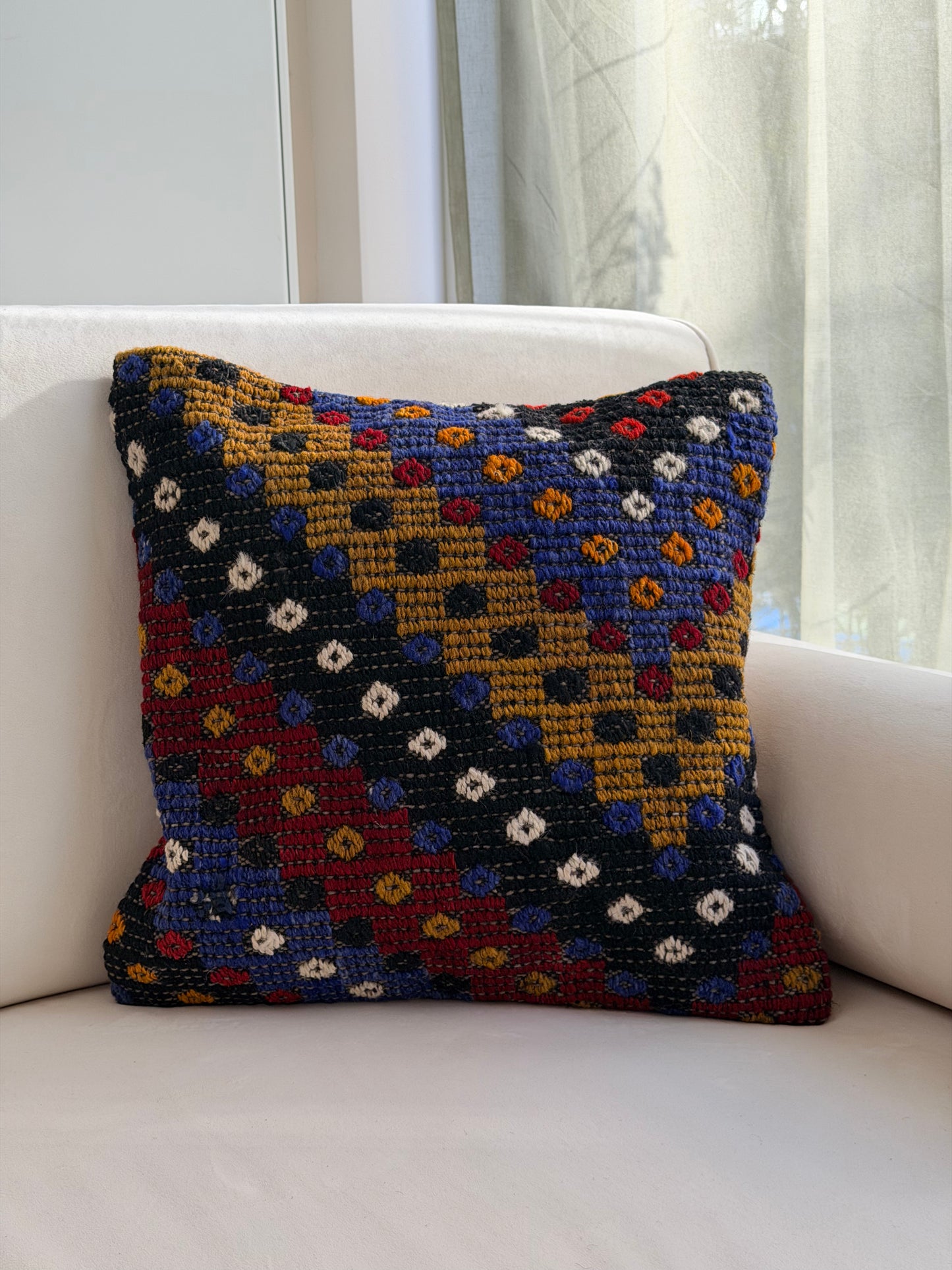 Textured Anatolian "pıtırak" weave cushion cover with colorful geometric motifs on a charcoal wool base
