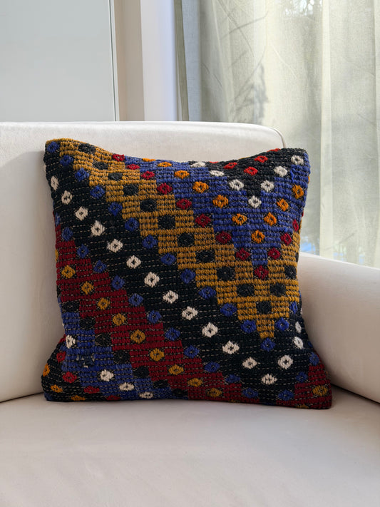 Textured Anatolian "pıtırak" weave cushion cover with colorful geometric motifs on a charcoal wool base