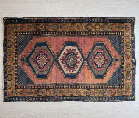 Vintage Anatolian wool rug with geometric patterns on a plain background