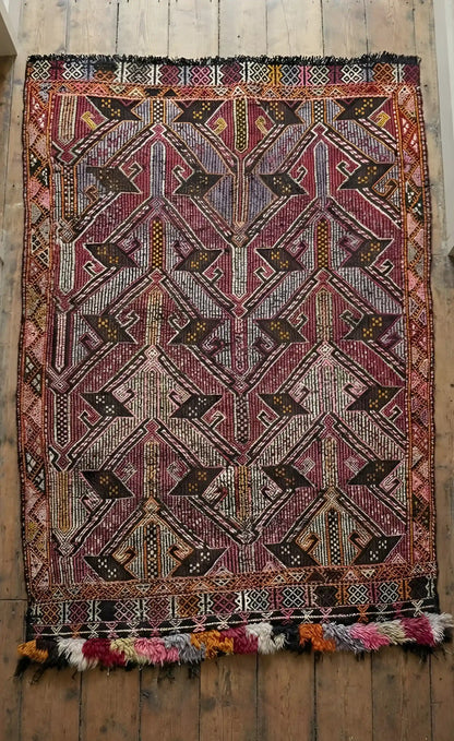 Anatolian rug with intricate patterns on a wooden floor