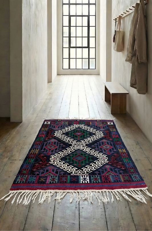 Anatolian kilim rug with geometric pattern on wooden floor with large window