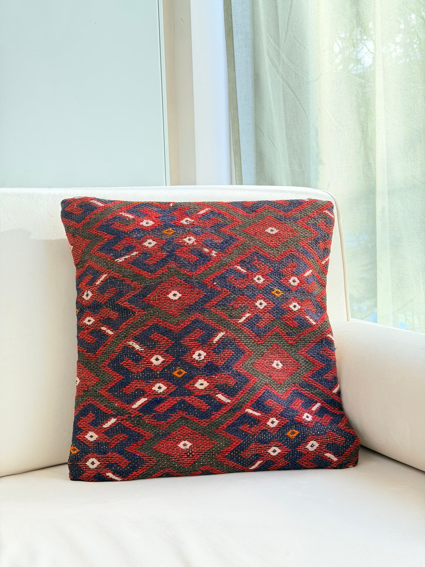 Classic geometric kilim pillow cover featuring red and navy diamond motifs, repurposed from a vintage Turkish rug