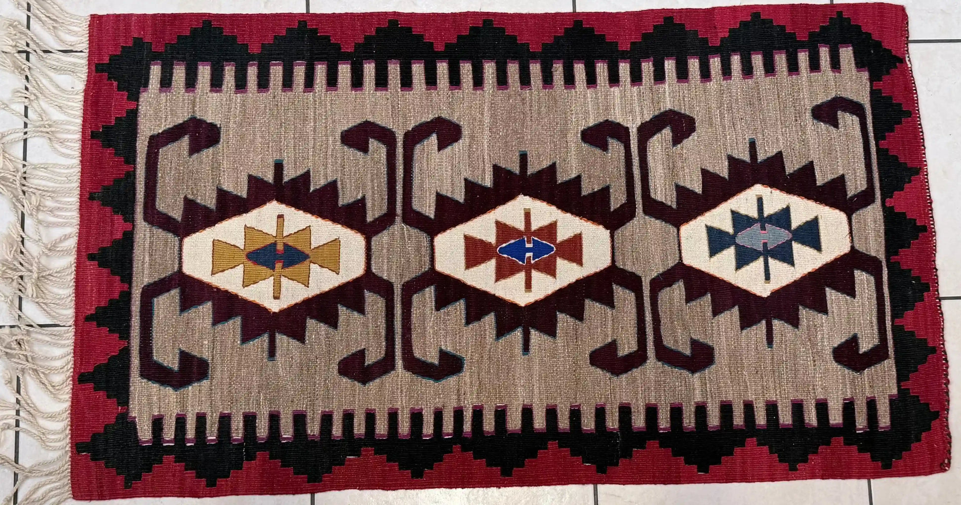 Anatolian kilim rug with geometric pattern on a tiled floor