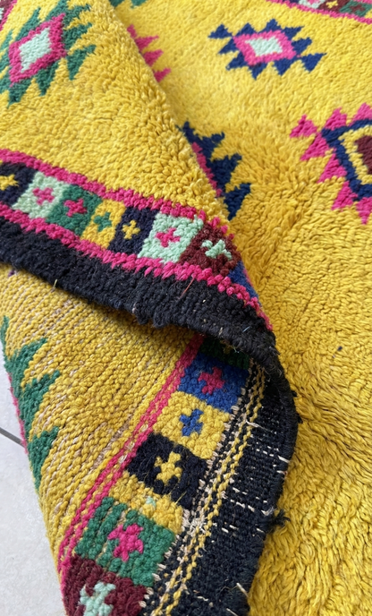 Close-up of a vibrant yellow Anatolian rug with intricate patterns and colors