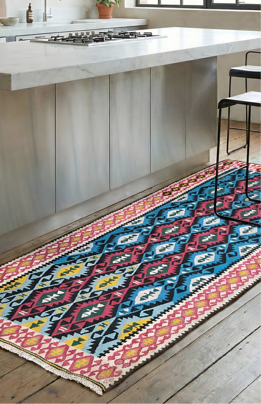 A vibrant, vintage Turkish Kilim runner featuring a colorful geometric diamond styled near kitchen island