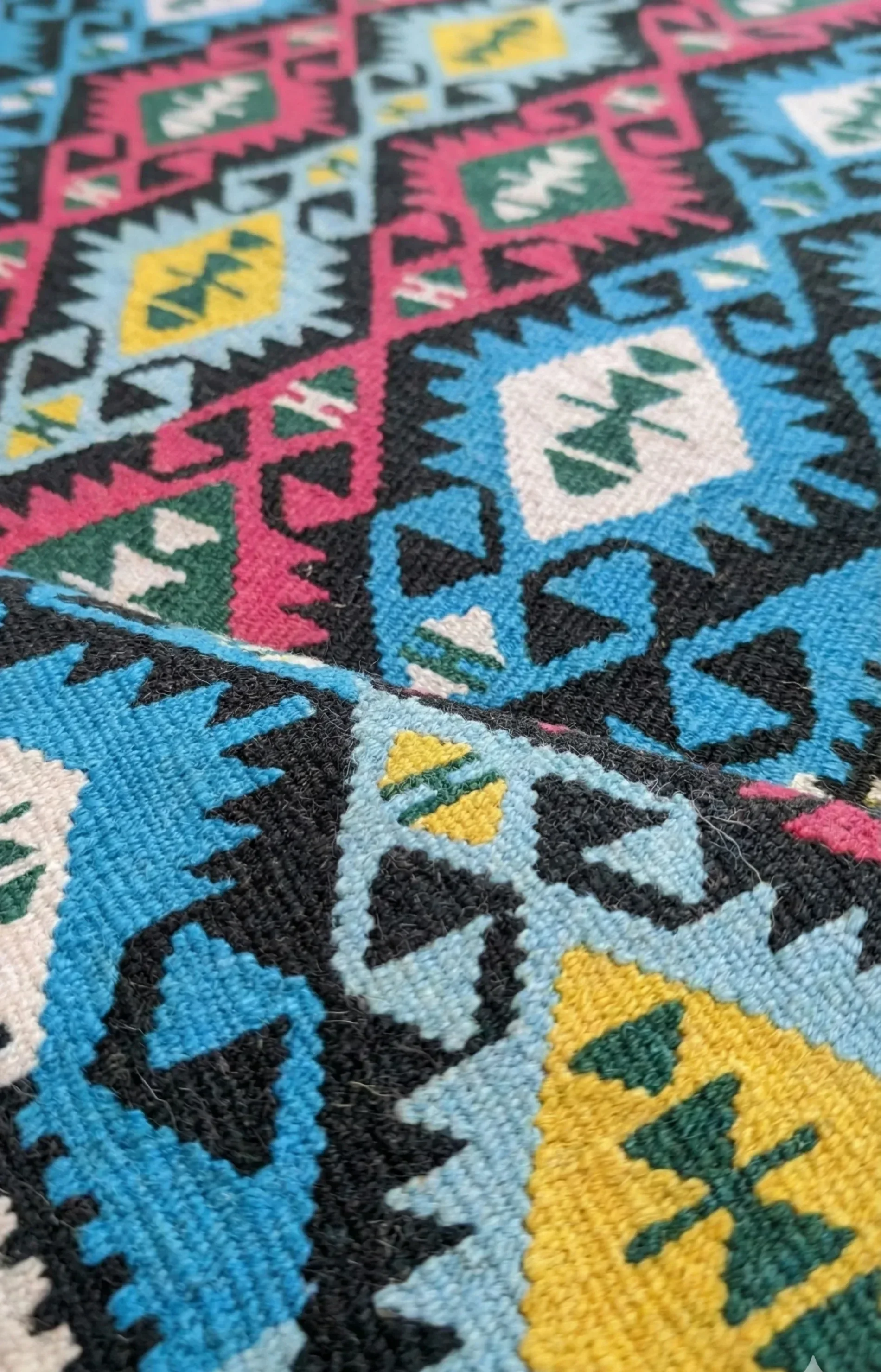 A vibrant, vintage Turkish Kilim runner featuring a colorful geometric pattern in turquoise, pink, and yellow