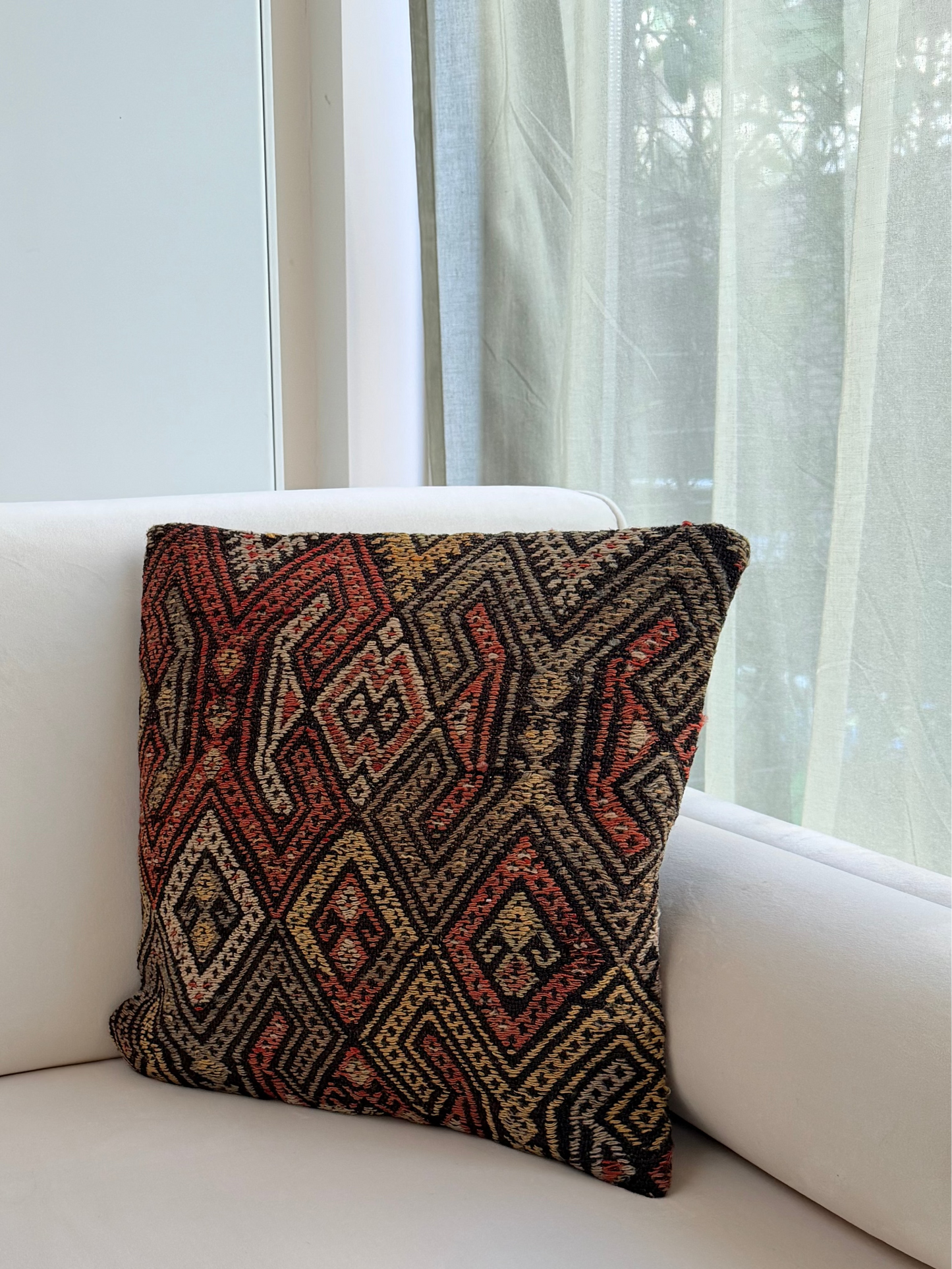 Handwoven Anatolian kilim cushion cover with traditional geometric diamond motifs in terracotta and charcoal wool