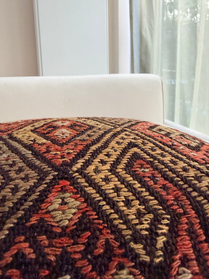 Handwoven Anatolian kilim cushion cover with traditional geometric diamond motifs in terracotta and charcoal wool